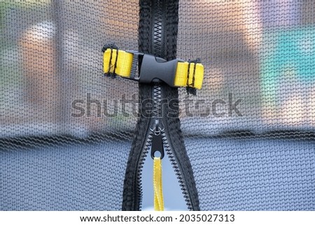 Close-up of a trampoline net fastener. A defense mechanism so as not to fly out when jumping. Close-up, horizontal photo. Safety, reliability