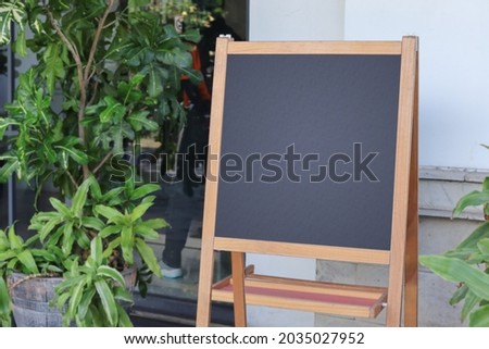 Restaurant sidewalk chalkboard sign shop board. Empty menu board stand. Freestanding blackboard frame in front of cafe