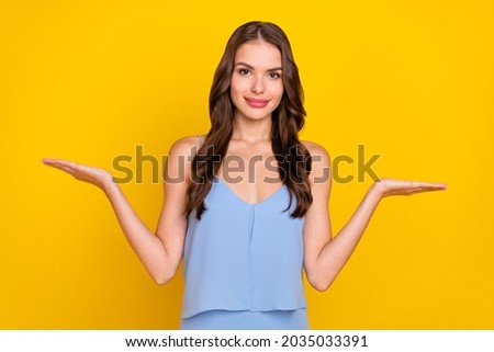 Photo of young attractive woman happy positive smile hold hand product promo alternative isolated over yellow color background