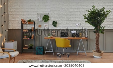 Decorative living room and working from home, interior concept, wooden desk, laptop, green plant.