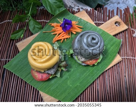 Pumpkin and charcoal Chinese steamed bun with sesame tofu burger