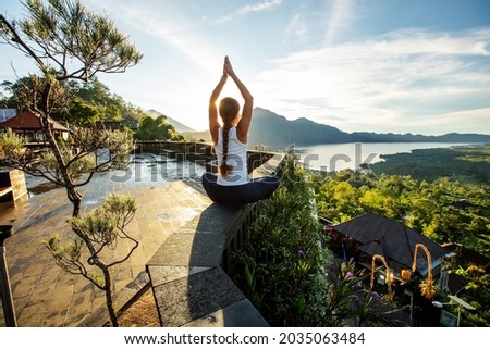 Woman doing yoga at dawn near a volcano on the island of Bali Royalty-Free Stock Photo #2035063484