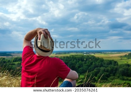 Young man admiring beautiful view of the forest landscape rear view.Young man standing alone summer day outdoor with wild forest on background. Travel Lifestyle concept back view