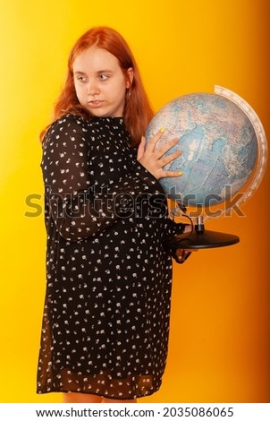 a girl on a middle background with red hair with a globe in her hands zooms in geography lesson and returns to school