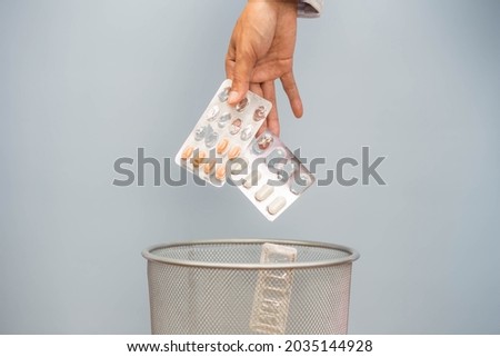 Expired medicine. Woman's hand throws expired medicine in the trash. Drug quality deterioration. Store the medication for a long time. Royalty-Free Stock Photo #2035144928