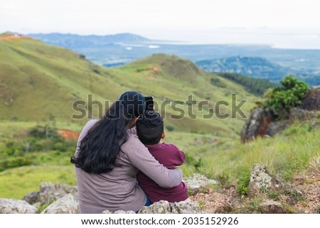 woman taking picture with her son in the mountains