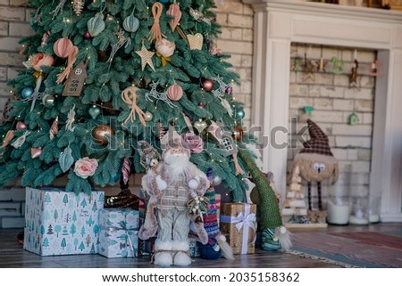 Decorated New Year's blue spruce near the Christmas fireplace with a wreath. Christmas celebration conceptSoft selective focus, art noise