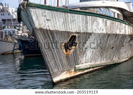old wooden boat on the sea in the harbor mooring port. rotten ruined wooden interior. cemetery 