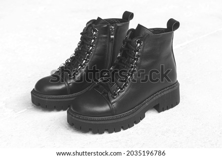 Black stylish footwear. Women boots on a concrete background. Female modern and casual style concept photo
