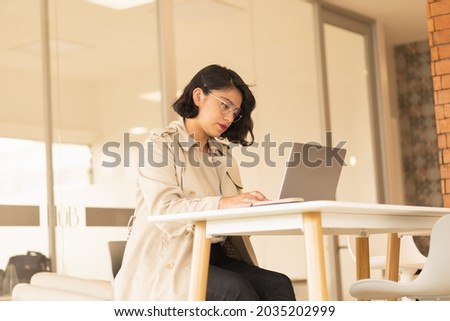 Young woman working, in a coworking space and video conferencing.