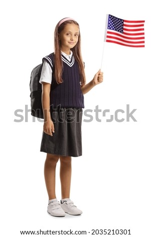 Full length portrait of a schoolgirl waving a small US flag isolated on white background