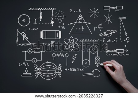 hand writes with chalk on a blackboard formulas, graphs and draws diagrams, the concept of study, school, education, exams, tests, physics concept Royalty-Free Stock Photo #2035226027
