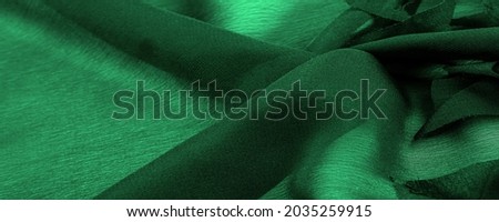 Texture. Background. Green silk fabric, view from above. Smooth elegant green silk or satin luxury cloth texture can use as abstract background with copy space.