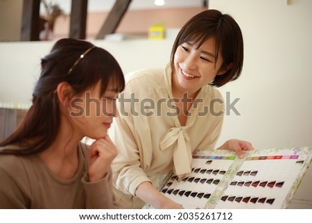 Image of a beautician showing a color chart  Royalty-Free Stock Photo #2035261712