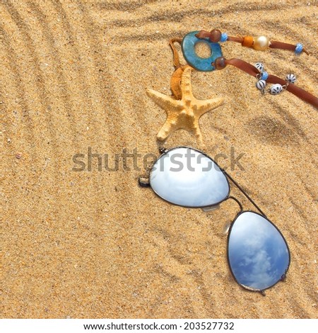 Sunglasses and  different objects on the beach