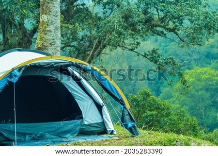 blue tent on camping ground. morning view in campsite on top of mountain. adventure photography, good for wallpaper and background.
