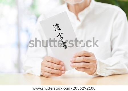 An elderly person with a smile and testament. Japanese translation: testament Royalty-Free Stock Photo #2035292108