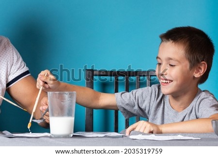 Children's creativity. Father and son paint with paint on blue background