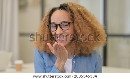 Flying Kiss by Smiling African Woman