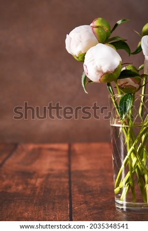 Beautiful still life with white peonies on a dark background. A delicate romantic bouquet for a wedding, holiday, anniversary. A picture for a postcard.