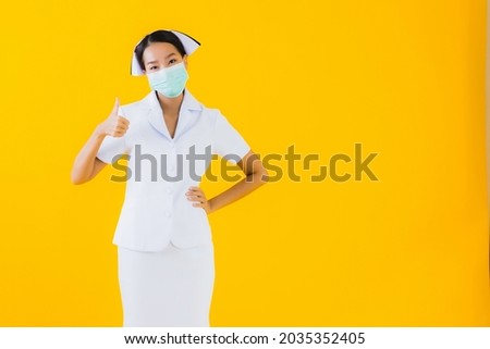 Portrait beautiful young asian woman thai nurse wear mask for protect covid19 or coronavirus and show alcohol gel on yellow isolated background