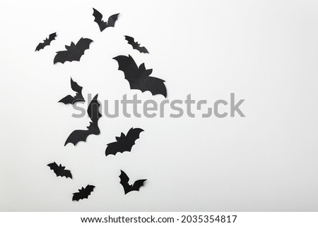 halloween and decoration concept - black paper bats flying over white background, copy space