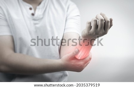 Muscle pain, arm pain, burning sensation, weak muscles, Office syndrome, Muscle tear caused by exercise, red inflamed zone. man having arm pain on a gray background. concept of health care Royalty-Free Stock Photo #2035379519