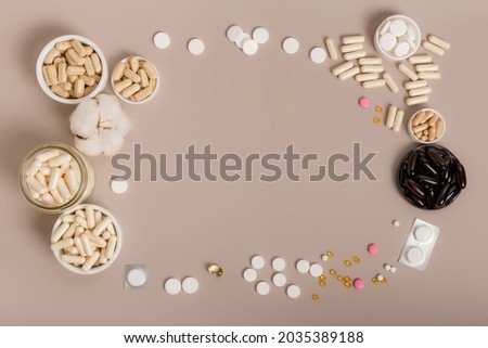 Flat lay view of nutritional supplements and multivitamins for help to support high immune system. Vitamins to avoid illnesses. Top view of vitamins on light neutral background. Pills and medications Royalty-Free Stock Photo #2035389188