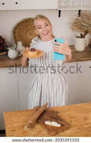 A housewife or pastry chef takes a selfie with dessert. Food blog. Cooking courses. Blogger woman