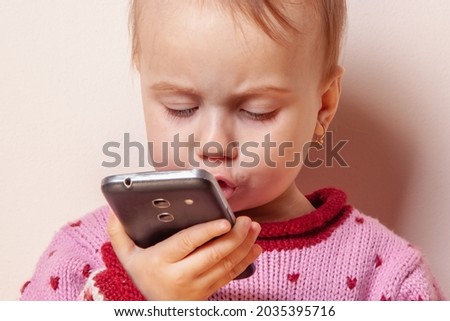 Little cute child girl use apps for help for children on mobile phone