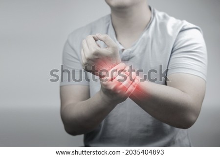 Wrist pain, myositis, muscle weakness, red zone inflammation. Man with wrist pain on gray background. concept of health care  Royalty-Free Stock Photo #2035404893
