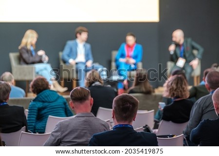 Audience listens to panel discussion at conference hall, rear view Royalty-Free Stock Photo #2035419875