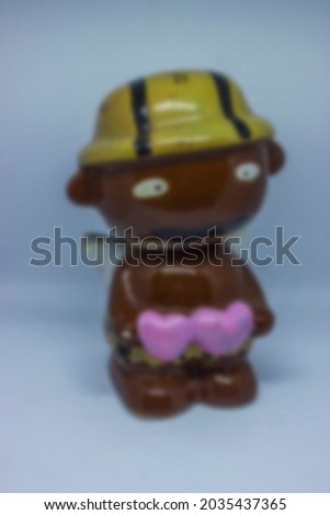 blur photo of the doll -shaped figurine is brown and holds two pink hearts