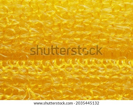 close up, background, texture, large horizontal banner. heterogeneous surface structure bright saturated yellow sponge for washing dishes, kitchen, bath. full depth of field. high resolution photo