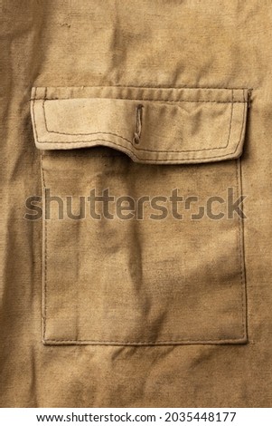 Pocket of an old military jacket in khaki canvas Royalty-Free Stock Photo #2035448177
