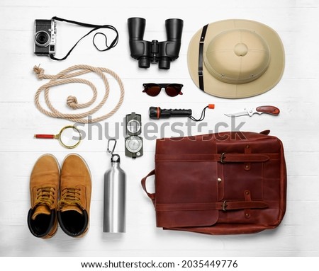 Flat lay composition with different safari accessories on white wooden background