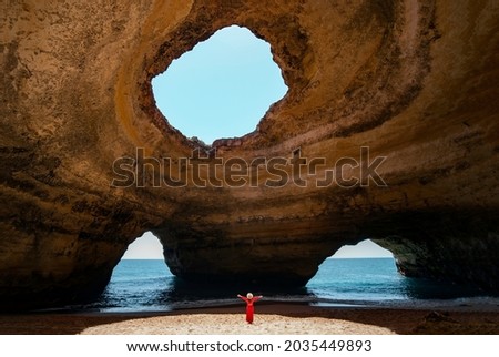 Traveler woman enjoying alone the beaches of the Algarve, Portugal Royalty-Free Stock Photo #2035449893