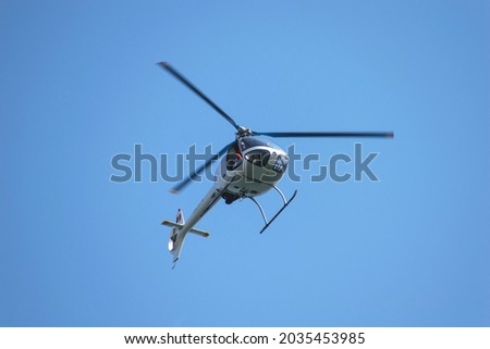 Small helicopter in flight. Helicopter for two people. Royalty-Free Stock Photo #2035453985