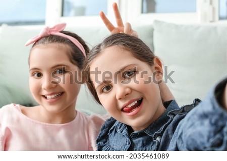 Portrait of cute twin girls at home