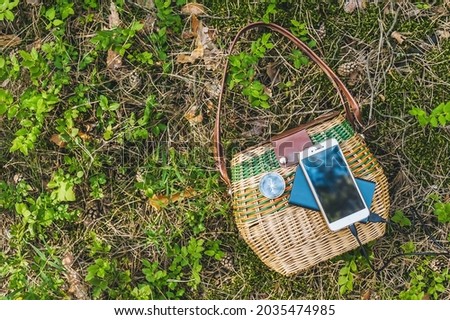 Close-up, Powerbank with smartphone on a basket in the forest. Travel concept