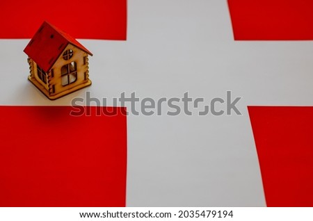 Real estate in Switzerland.Wooden house on the Swiss flag. Property, rent or mortgage concept