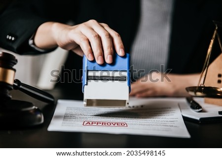 Law firm office, Close up of hand female lawyer stamping certificated approved on document legal, judges gavel, brass scale, scales of justice, justice advice service concept. Royalty-Free Stock Photo #2035498145