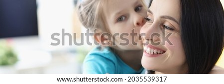 Little girl kissing smiling mom at home