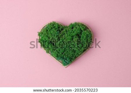Cosmetic background with a wooden heart and moss on pink. Flat lay, copy space