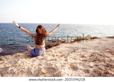 person with raised hands in the nature landscape scene, feeling happy and free