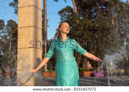 Mature blonde in the summer in the fountain