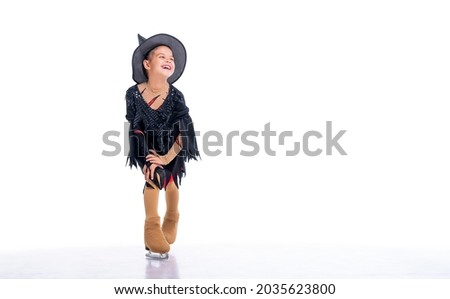 Little young skater posing in halloween witch costume on ice arena on white background