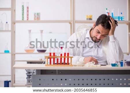 Young male chemist extremely tired at the lab
