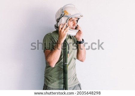Military man with astronaut cosmonaut helmet, on a white wall