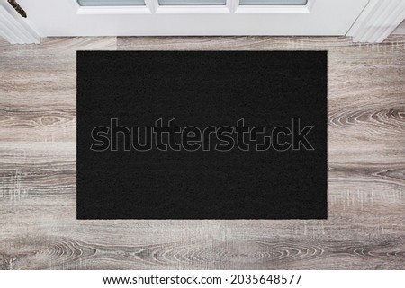 Black Coir Doormat on wooden floor in front of the door. Product mockup Royalty-Free Stock Photo #2035648577